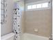 Clean bathroom featuring neutral tile, a shower-tub combo, and modern fixtures at 130 Skipwith Dr, Wendell, NC 27591