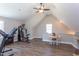 Bright bonus room featuring a ceiling fan, exercise equipment, wood floors, and a table near the window at 130 Skipwith Dr, Wendell, NC 27591