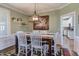 Stylish dining room with wainscoting, a modern chandelier, and a view of the bright kitchen at 130 Skipwith Dr, Wendell, NC 27591