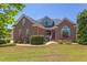 Beautiful brick home featuring manicured landscaping, arched windows and a welcoming front porch at 130 Skipwith Dr, Wendell, NC 27591