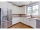 Kitchen with stainless steel appliances and white cabinets with red brick style backsplash at 130 Skipwith Dr, Wendell, NC 27591