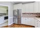 Bright kitchen with stainless steel refrigerator and white cabinets at 130 Skipwith Dr, Wendell, NC 27591