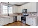 Well-lit kitchen featuring stainless steel appliances, white cabinets, and a modern design at 130 Skipwith Dr, Wendell, NC 27591