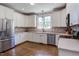 Well-lit kitchen featuring white cabinets, stainless steel appliances, and brick backsplash at 130 Skipwith Dr, Wendell, NC 27591