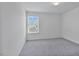 This carpeted bedroom features a bright window overlooking the exterior at 1305 Addison Lake St, Fuquay Varina, NC 27526