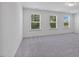 Large bonus room with neutral carpet and three windows overlooking the backyard at 1305 Addison Lake St, Fuquay Varina, NC 27526