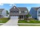 Charming two-story home featuring stone accents, a two-car garage, and professionally landscaped front yard at 1305 Addison Lake St, Fuquay Varina, NC 27526