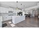 Modern kitchen with an island, stainless appliances, pendant lights, and a view of the dining and living areas at 1305 Addison Lake St, Fuquay Varina, NC 27526