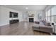 Spacious living room with a gray sectional sofa, a fireplace, and wood floors at 1305 Addison Lake St, Fuquay Varina, NC 27526