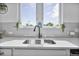 Close-up of a kitchen sink and window, with light gray backsplash and quartz countertop at 1305 Addison Lake St, Fuquay Varina, NC 27526