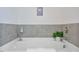 Close up of the soaking tub with neutral colored tiles and decor at 1305 Addison Lake St, Fuquay Varina, NC 27526