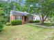 Charming brick home featuring a well-manicured lawn, mature trees, and classic architectural details at 1313 Ridge Rd, Raleigh, NC 27607