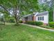 This well-maintained home is surrounded by lush landscaping and vibrant green grass at 1313 Ridge Rd, Raleigh, NC 27607