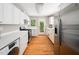 Bright kitchen with white cabinets, stainless steel appliances, and an exterior door with natural light at 1313 Ridge Rd, Raleigh, NC 27607