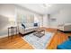 A bright and airy living room with hardwood floors, a fireplace, and a window with blinds at 1313 Ridge Rd, Raleigh, NC 27607