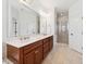 Primary bathroom featuring a double sink vanity with wood cabinets, large mirror, and glass enclosed shower at 1328 Palace Garden Way, Raleigh, NC 27603