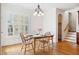 Bright dining room featuring a white table, wood chairs, chandelier, and large windows with plantation shutters at 1328 Palace Garden Way, Raleigh, NC 27603