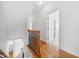 Upstairs hallway with hardwood floors, white walls, wood and wrought iron banister, and open doorways at 1328 Palace Garden Way, Raleigh, NC 27603