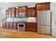 Kitchen featuring stainless steel appliances, brown cabinets, and a tile backsplash at 1328 Palace Garden Way, Raleigh, NC 27603