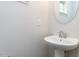 Charming powder room featuring a pedestal sink and round mirror providing a simple yet elegant design at 1380 Channing Park Cir, Cary, NC 27519