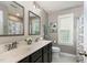 Bright bathroom with double sink vanity, framed mirrors, toilet, and a window for natural light at 1424 Forest Fern Ln, Fuquay Varina, NC 27526
