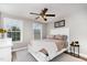 Cozy bedroom with a white bed frame, gray walls, hardwood floors, and natural light from two windows at 1424 Forest Fern Ln, Fuquay Varina, NC 27526
