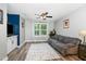 Inviting living room with hardwood floors, ceiling fan, sofa, TV, and a large window at 1424 Forest Fern Ln, Fuquay Varina, NC 27526
