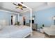 Spacious main bedroom with a tray ceiling, four-poster bed, walk-in closet, and serene blue walls at 1424 Forest Fern Ln, Fuquay Varina, NC 27526