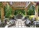 Inviting outdoor patio with a pergola, stone fountain, and comfortable seating area for relaxing or entertaining at 1424 Forest Fern Ln, Fuquay Varina, NC 27526