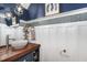 Elegant powder room featuring blue walls, white wainscoting, and a modern vessel sink on a wooden countertop at 1424 Forest Fern Ln, Fuquay Varina, NC 27526