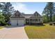 Traditional home featuring a two-car garage, inviting front porch, and manicured lawn at 15 Clearwater Harbour Hbr, Sanford, NC 27332