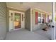 Inviting front porch with decorative glass door, wood shutters and comfortable seating at 15 Clearwater Harbour Hbr, Sanford, NC 27332