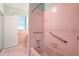 The pink bathroom features safety bars, matching tiles and fixtures, and a window for natural light at 1502 Washington St, Durham, NC 27701