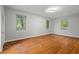 Bedroom with hardwood floors, neutral walls and three bright windows at 1502 Washington St, Durham, NC 27701