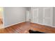 Empty bedroom with hardwood floors and three doors including entry, closet, and possible ensuite bath at 1502 Washington St, Durham, NC 27701