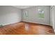 An empty bedroom with hardwood floors, gray walls and a pair of windows letting in plenty of light at 1502 Washington St, Durham, NC 27701