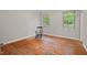 Spacious empty bedroom with hardwood floors and a pair of windows letting in plenty of light at 1502 Washington St, Durham, NC 27701