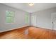 Empty bedroom with hardwood floors, light gray walls and a pair of windows letting in plenty of light at 1502 Washington St, Durham, NC 27701