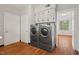 The laundry room has a washer and dryer, along with storage cabinets and hardwood floors at 1502 Washington St, Durham, NC 27701