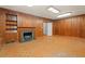 Living room with wood paneling, a fireplace, and built-in cabinets at 1502 Washington St, Durham, NC 27701