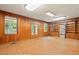 Living room with wood paneling, built-in shelving, and large windows at 1502 Washington St, Durham, NC 27701