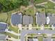 An aerial view shows homes with manicured lawns on a tree-lined street in a residential community at 1605 Silo Point Dr, Wake Forest, NC 27587