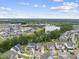 A community overview showcases a scenic pond surrounded by homes and verdant trees against a blue sky at 1605 Silo Point Dr, Wake Forest, NC 27587