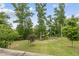 The expansive backyard is beautifully landscaped with various trees and shrubbery at 1605 Silo Point Dr, Wake Forest, NC 27587