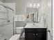 Well-lit bathroom featuring a shower, toilet, and dark wood vanity with a white countertop at 1605 Silo Point Dr, Wake Forest, NC 27587