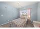 Charming bedroom with chandelier, light-blue walls, and a bright window with sheer pink curtains at 1605 Silo Point Dr, Wake Forest, NC 27587
