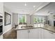 Bright kitchen featuring an island, stainless steel sink, wood floors, and an adjacent dining area with natural light at 1605 Silo Point Dr, Wake Forest, NC 27587