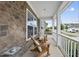 Cozy front porch featuring stone accents and a seating area with two wood chairs at 1605 Silo Point Dr, Wake Forest, NC 27587