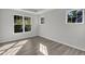 A bedroom featuring hardwood floors, lots of natural light, a tray ceiling, and neutral paint at 1665 Wilde Bnd, Apex, NC 27523