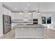 Well-equipped kitchen featuring stainless steel appliances, white cabinetry and a functional island at 1665 Wilde Bnd, Apex, NC 27523